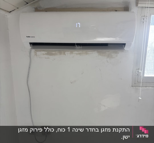 מזגן מותקן על קיר לבן ליד חלון